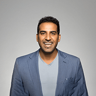 Ai Automation Solutions For Customer Engagement - Desku A man in a blue suit is smiling while using customer support software for ai customer service.