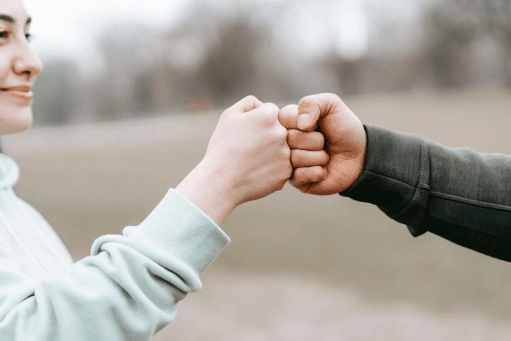 12 Customer Service Phrases To Strengthen Client Relationships - Desku The man and woman exchange a friendly handshake at the park.